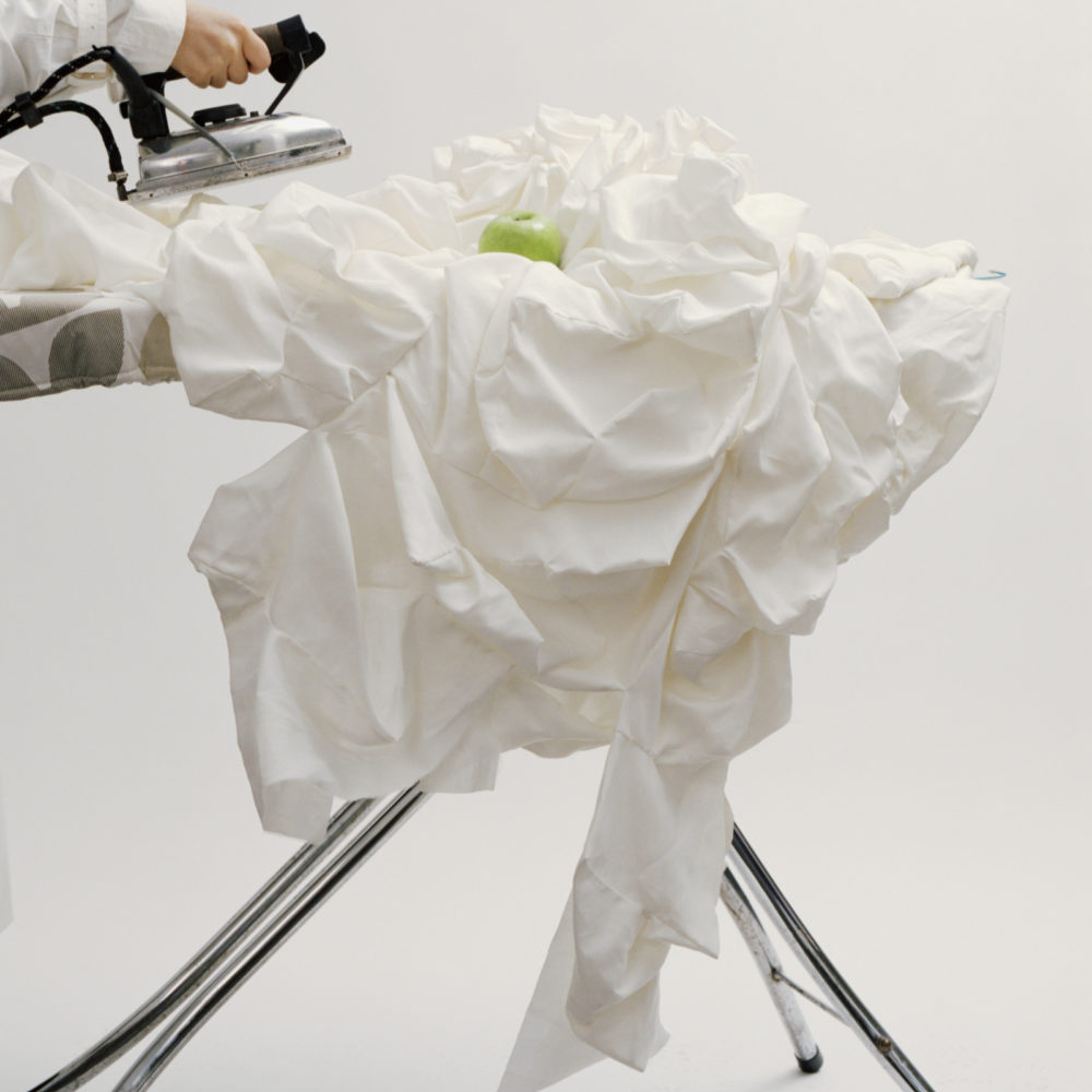 Crumpled fabric being ironed